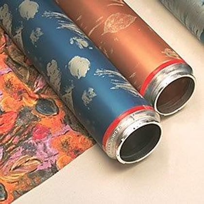 Laser-engraved rotary printing screens carrying their patterns, beside the printed fabric