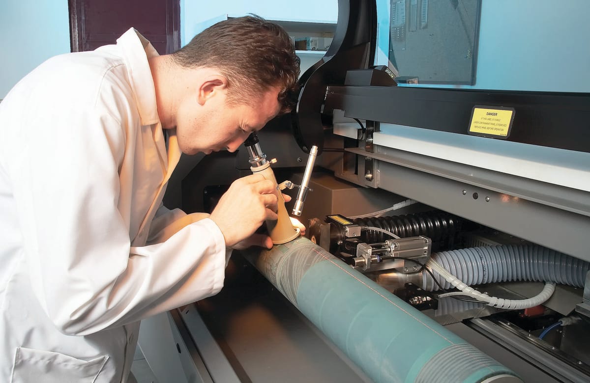 Technician inspecting an engraved surface with an optical instrument