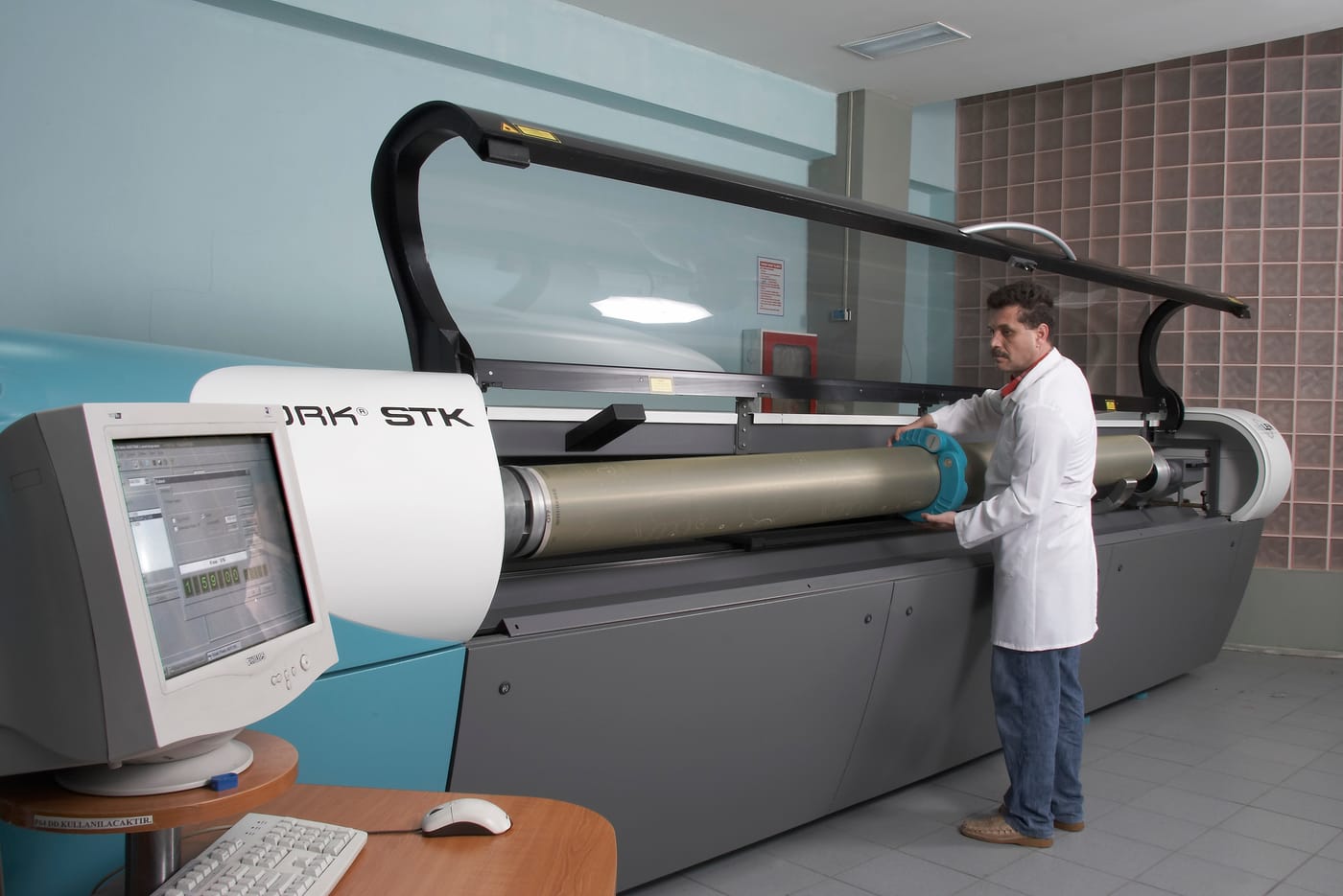 STK lazer gravür makinesinde silindir işlenirken operatör kontrolde